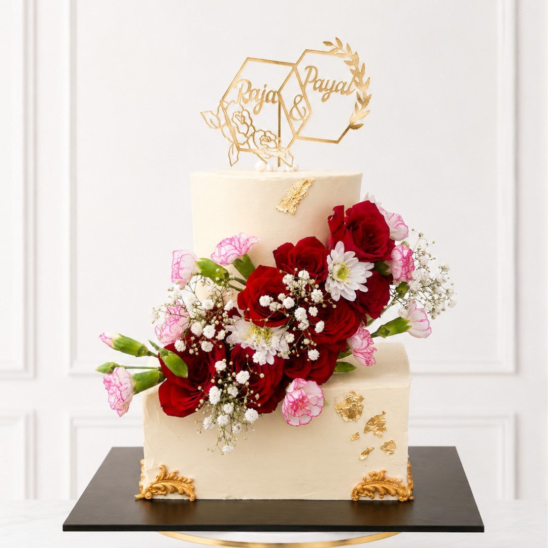 Decorative cake with flowers and a gold topper on a white background