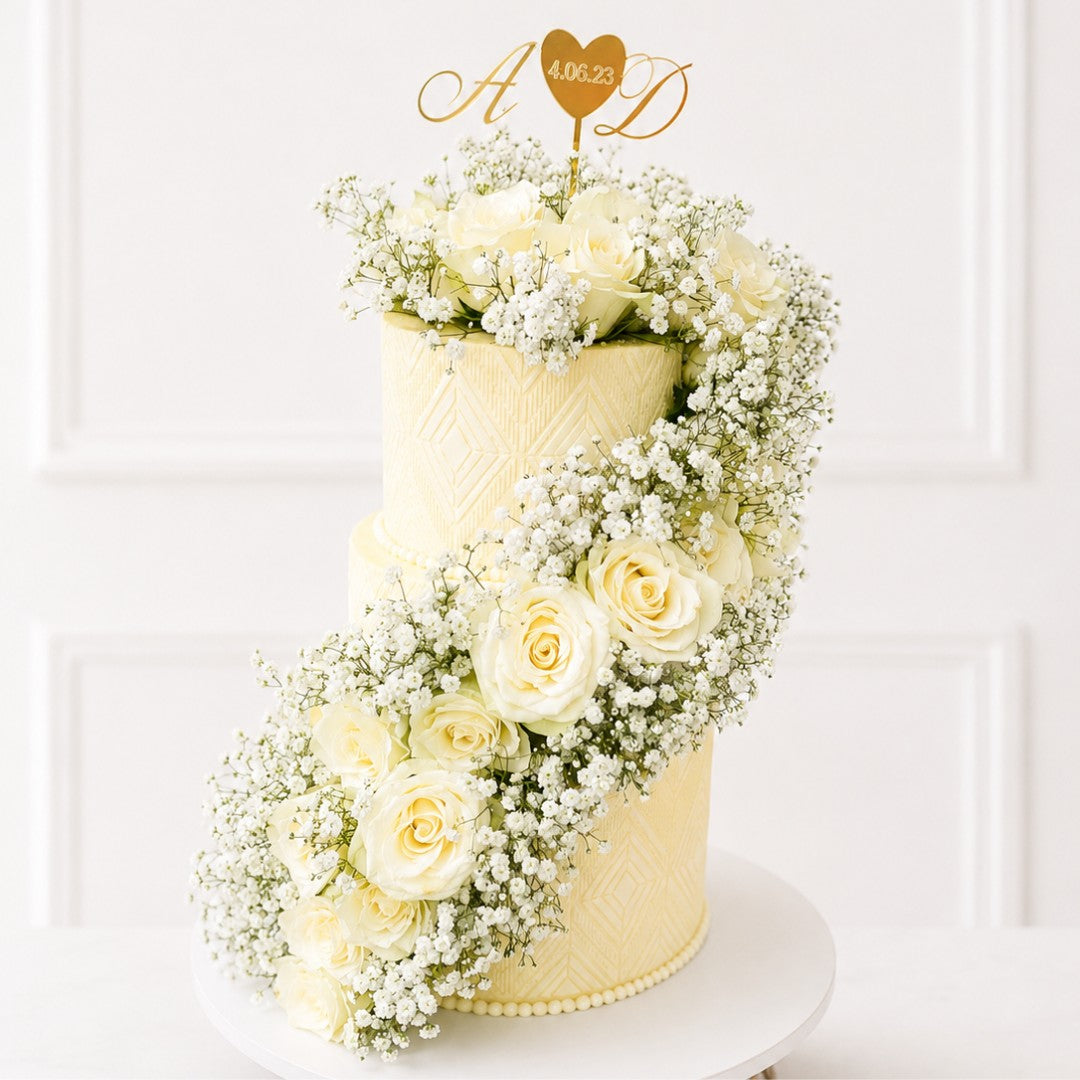 Two-tiered wedding cake decorated with white flowers on a white background