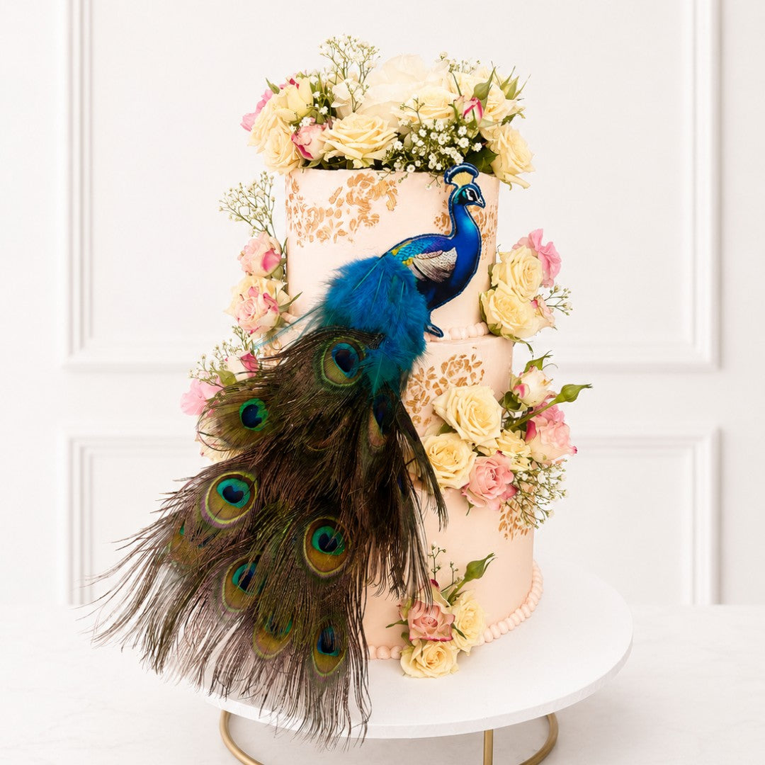 Decorative cake with peacock feathers and flowers on a white background