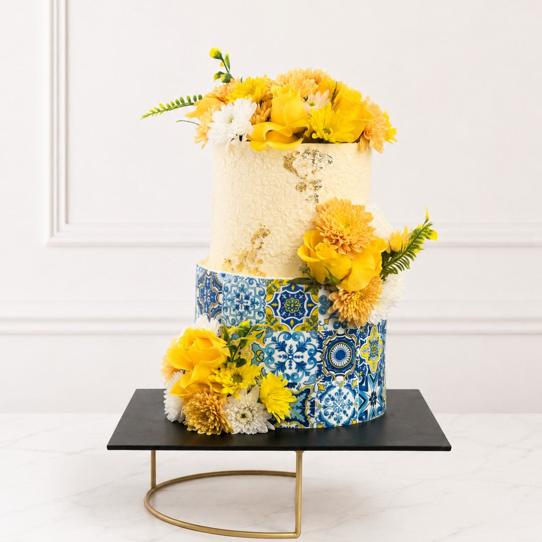 Two-tiered cake with floral decorations on a white background